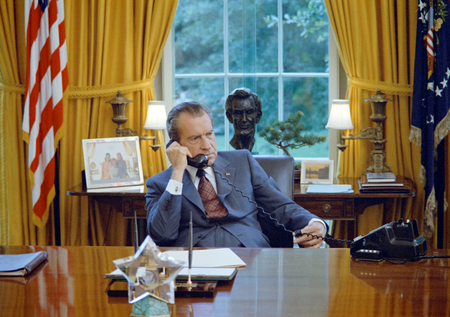 President Richard Nixon seated at his desk in the White House Oval Office