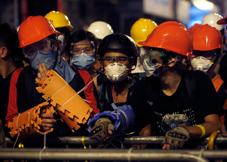 Pro-democracy protesters protect themselves with helmets, masks and foam pads during a standoff with riot police at the Mongkok shopping district