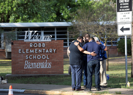 People hug outside Robb Elementary School, the scene of a mass shooting in Uvalde, Texas, U.S.