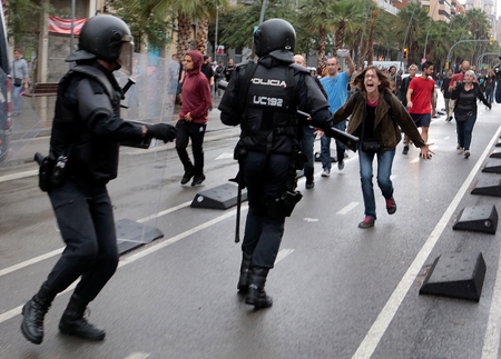 A woman yells at riot police near a a polling station for the banned independence referendum in Barcelona, Spain, October 1, 2017.