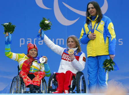 Ukraine&#039;s Olena Iurkovska covers her bronze medal with her hand after finishing third in the women&#039;s biathlon 12,5 km sitting event as she and first place Svetlana Konovalova of Russia, center and second place Anja Wicker of Germany pose during a medal ceremony at the 2014 Winter Paralympics, Friday, March 14, 2014, in Krasnaya Polyana, Russia. The majority of Ukraine&#039;s Paralympic medalists covered their medals during medal ceremonies. (AP Photo/Dmitry Lovetsky)
