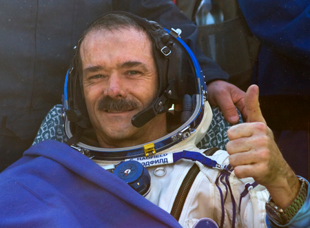 Canadian astronaut Chris Hadfield gestures after the Russian Soyuz space capsule landed some 150 kilometers (94 miles) southeast of the town of Dzhezkazgan in central Kazakhstan, Tuesday, May 14, 2013. The Soyuz space capsule carrying a three-man crew returning from a five-month mission to the International Space Station landed safely Tuesday on the steppes of kazakhstan. (AP Photo/ Sergei Remezov, Pool)