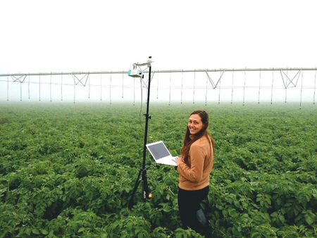 A Prospera scientist working with a camera mounted on a movable sprinkler system.