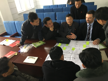 Ian Collins explains the business model canvas to a huddle of North Korean seminar participants.