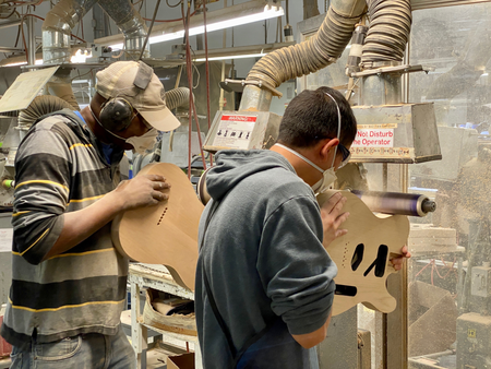 Workers sanding guitar bodies at the Fender plant.