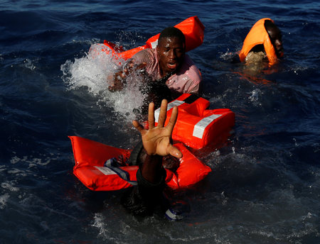 Migrants try to stay afloat after falling off their rubber dinghy during a rescue operation by the Malta-based NGO Migrant Offshore Aid Station (MOAS) ship in the central Mediterranean in international waters some 15 nautical miles off the coast of Zawiya in Libya, April 14, 2017. All 134 sub-Saharan migrants survived and were rescued by MOAS.