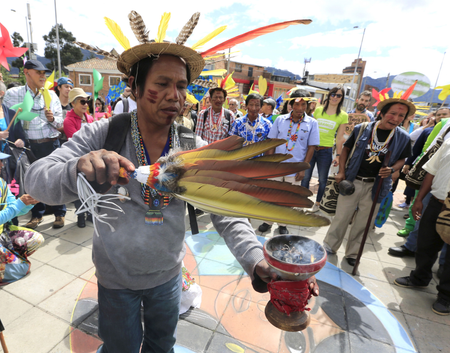A Colombian Barzano Indian performs a rite ahead of a climate march in Bogota, Colombia.