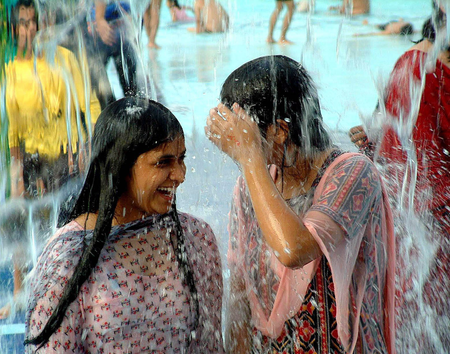 Girls smile as they enjoy a shower in a water park to in the outskirts of Bhopal.