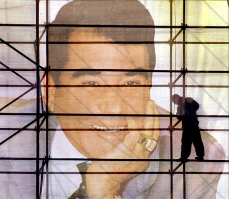 Turkmen workers work on a giant poster with a portrait of President Saparmurat Niyazov in Ashgabat, December 28, 2002.