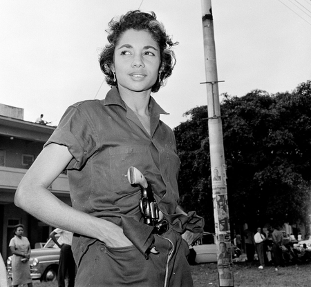 A young unidentified woman patrols near a headquarters building in Havana, Jan. 4, 1959.