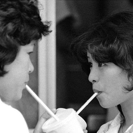 Two young girls sipping milk shakes in Japan.