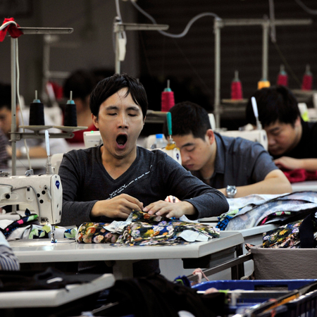 An employee yawns as he works at a garment factory in Humen township, Guangdong province November 24, 2013. Activity in China&#039;s vast factory sector grew at a milder pace in November as new export orders shrank, a preliminary survey showed on Thursday, bolstering expectations the economy could lose some of its vigour in the fourth quarter as Beijing shifts its focus to structural reform. Picture taken November 24, 2013.