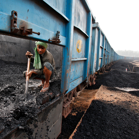 Worker unloads coal from a goods train at a railway yard in Chandigarh