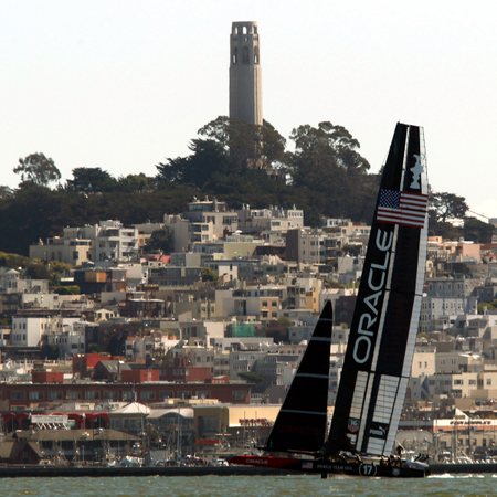 Oracle Team USA sails near the city skyline against Emirates Team New Zealand during Race 14 of the 34th America&#039;s Cup yacht sailing race in San Francisco, California September 22, 2013.