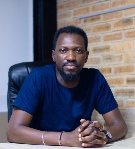 Olugbenga Agboola, Flutterwave&#039;s CEO, sitting on a chair and looking into the camera
