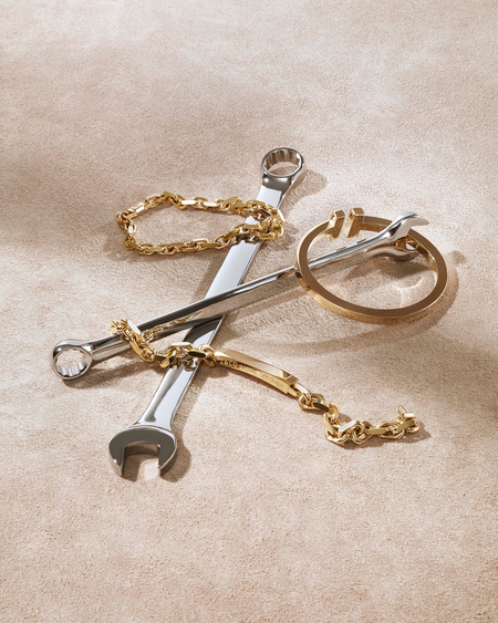Gold Tiffany men&#039;s bracelets lie on top of wrenches