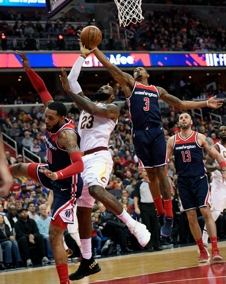 Cleveland Cavaliers forward LeBron James (23) goes to the basket against Washington Wizards guard Bradley Beal (3), forward Mike Scott, left, and Washington Wizards center Marcin Gortat (13), of Poland, during the first half of an NBA basketball game, Sunday, Dec. 17, 2017, in Washington. (AP Photo/Nick Wass)
