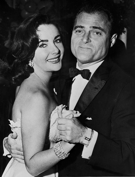 British-born US actress Elizabeth Taylor is pictured dancing with the film producer Mike Todd at a party in Greenwich, 09 december 1956. Mike Todd will become the next - and 3rd - husband of Liz Taylor in february 1957. (Photo credit should read -/AFP/Getty Images)