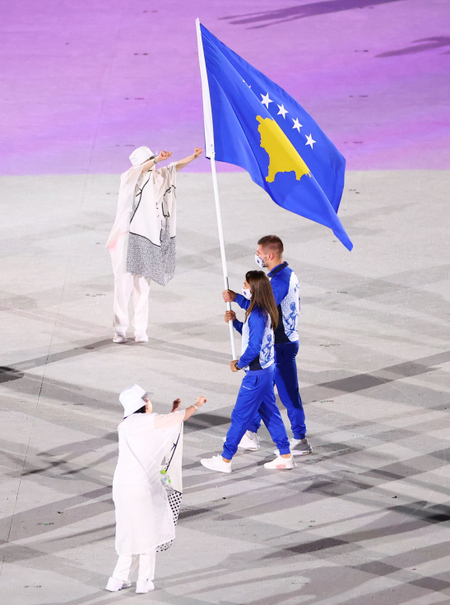 Athletes carrying the flag of Kosovo walk into the olympic arena in Tokyo