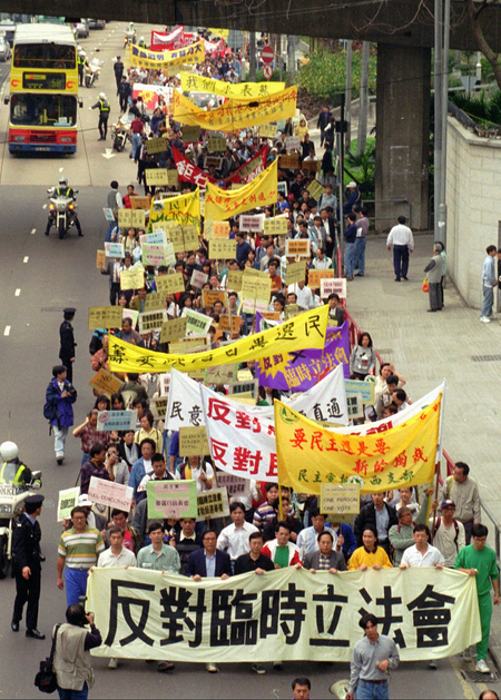 Led by legislators, more than 1,000 people join a rally Sunday, April 14, 1996, to protest China&#039;s plans to replace the current legislature with a Beijing-appointed legislature after Hong Kong returns to Chinese sovereignty in 1997. Sign at front reads &quot;Protest the setting up of the provisional legislature.&quot;