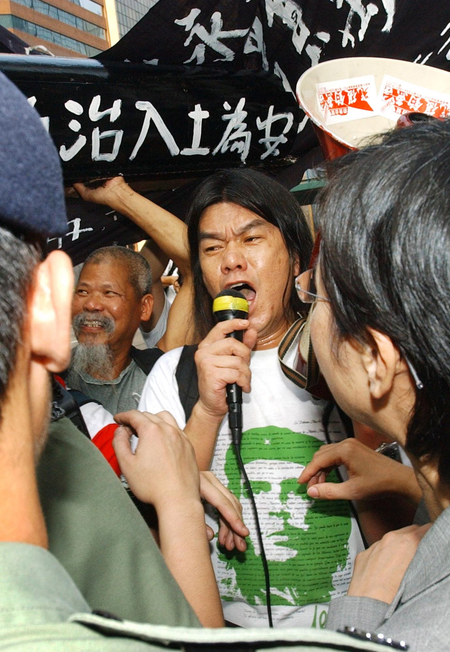Wearing his trademark Che Guevara t-shirt, Hong Kong activist &quot;Longhair&quot; Leung Kwok-hung shouts into a bullhorn during a protest in Hong Kong, July 1, 2004. The veteran gadfly is now hoping to take his message inside the halls of power by running for a legislative seat. Leung, who fell about 7,700 votes short in the last legislative election four years ago, believes massive anti-government sentiment will carry him to victory in the Sept. 12 contest.