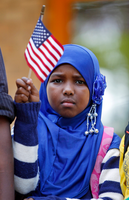 Ilhan Issa, a Somali-American girl from Minneapolis, waves an American flag.