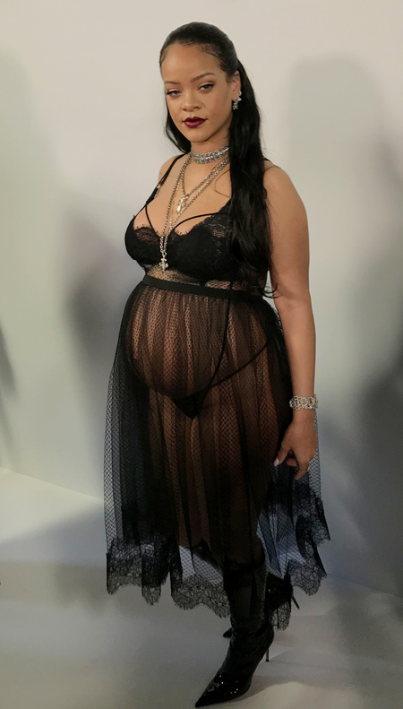 Rihanna wears a sheer black dress over lingerie.
