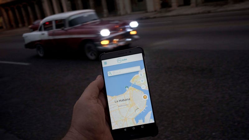 Man holds a phone with an app called Sube, Cuba’s homegrown version of Uber