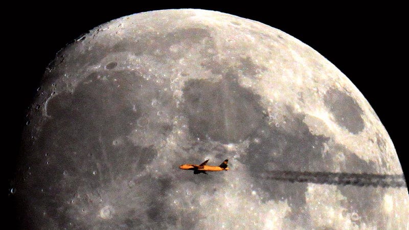 Illustration for article titled Perfectly Timed Pics of Airplanes Silhouetted Against the Sun and Moon