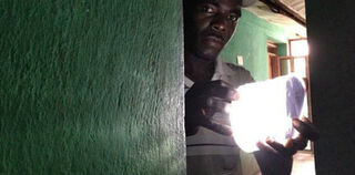 Farmer in Central Plateau of Haiti holding a solar-power light (Courtesy of Soleil Global)