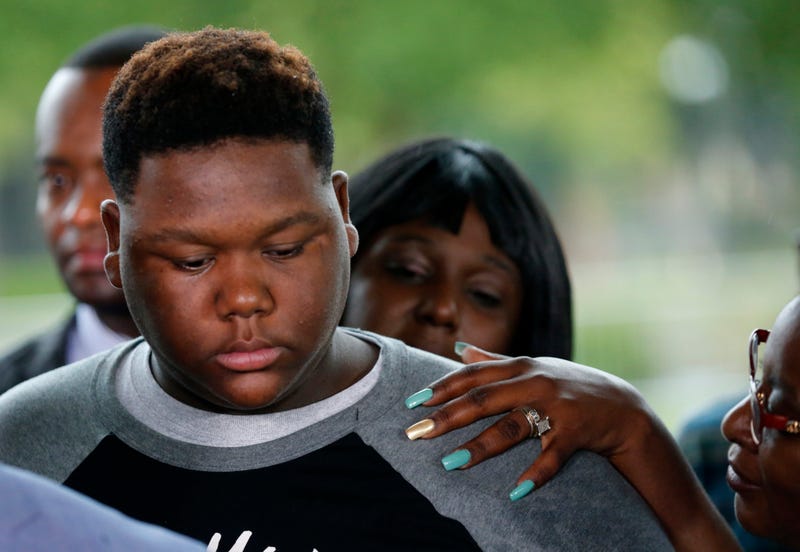 Cameron Sterling, son of Alton Sterling, is comforted as he listens to family and attorneys speak following a meeting with the U.S. Justice Department at federal court in Baton Rouge, La., Wednesday, May 3, 2017. An investigation into the police shooting death of Alton Sterling in Baton Rouge found that there was not enough evidence to prove that the white officers acted unreasonably and willfully, a federal prosecutor said Wednesday.