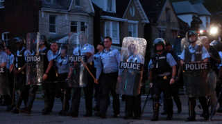 St. Louis police stand in riot gear after some 150 protesters gathered at the scene of the fatal police shooting of Mansur Ball-Bey. NBC News Screenshot