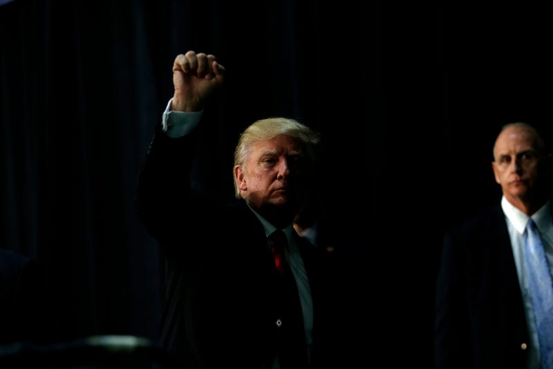 Donald Trump “gestures” to supporters, as Getty puts it, as he makes his way off stage following a rally on August 18, 2016 at the Charlotte Convention Center in Charlotte, North Carolina (Photo by Brian Blanco/Getty Images)