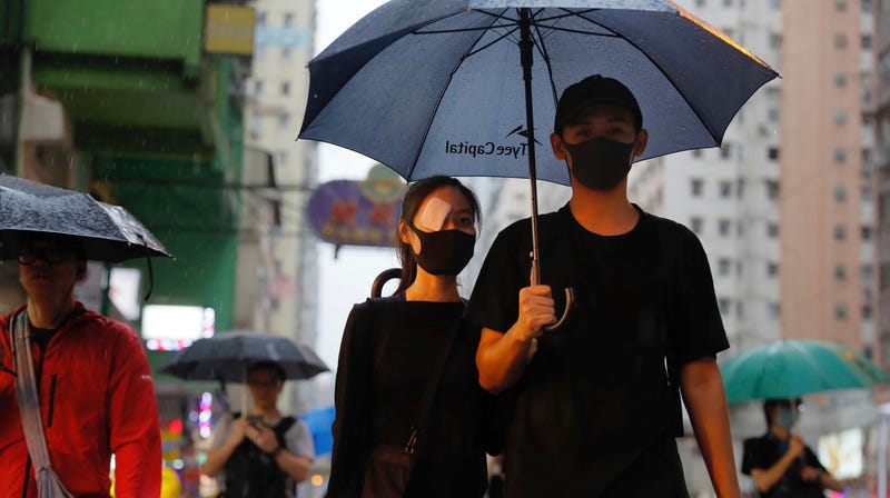 A demonstrator wears an eye patch to show solidarity with a woman injured in her eye by a beanbag during a previous protest as she marches along a street in Hong Kong, Sunday, Aug. 18, 2019.