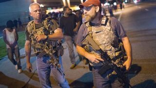 Oath Keepers, carrying rifles, walk along West Florissant Avenue in Ferguson, Mo., as demonstrators, marking the first anniversary of the fatal shooting of Michael Brown, protest Aug. 10, 2015.Scott Olson/Getty Images