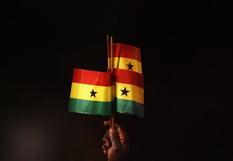 A Ghana fan holds up Ghanaian flags during an international soccer game. Ryan Pierse/Getty Images