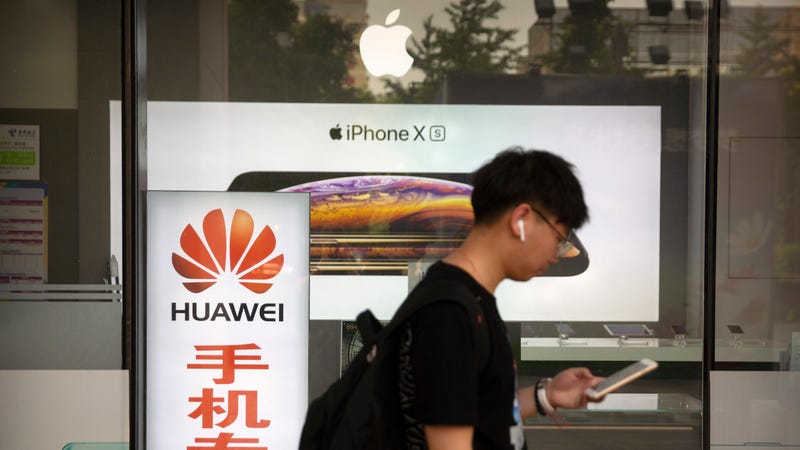 A man walks past an electronics store in Beijing in May 2019.