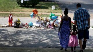 A family on Aug. 25, 2014, visits the memorial set up for Michael Brown on the spot he was shot in Ferguson, Mo.  Joe Raedle/Getty Images