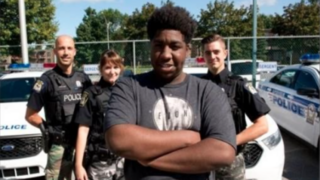 Malyk Bonnet poses with officers of the Laval Police Department in Quebec after his quick thinking helped officers catch a man who had kidnapped his former girlfriend. Laval Police Department