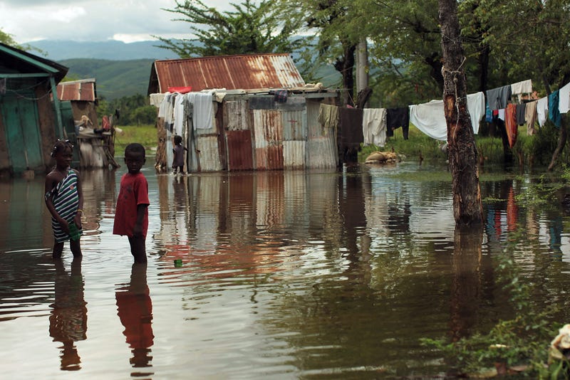Children stand outside their flooded homes on Nov. 6, 2010, in Petite Riviere, Haiti. (Spencer Platt/Getty Images)