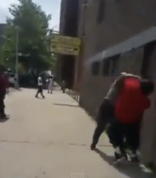 A plainclothes NYPD officer and Saykou George (in red) in Harlem on July 1, 2015YouTube screenshot