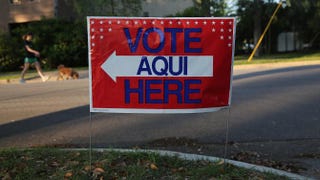 A bilingual sign stands outside a polling center at public library ahead of local elections April 28, 2013, in Austin, Texas. John Moore/Getty Images