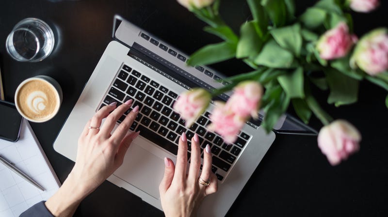 This stock-photo “blogger” can afford both fresh-cut flowers and a latte.