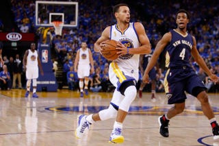 Stephen Curry of the Golden State Warriors drives to the hoop against Ish Smith of the New Orleans Pelicans during the NBA season opener in Oakland, Calif., Oct. 27, 2015.Ezra Shaw/Getty Images