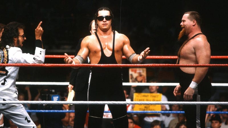 Bret “Hitman” Hart circa 1986 with manager Jimmy Hart and tag team partner Jim “The Anvil” Neidhart.
