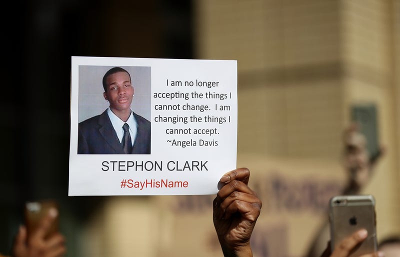 A protester holds a photo of Stephon Clark during a Black Lives Matter demonstration outside of Sacramento City Hall on March 22, 2018 in Sacramento, California.