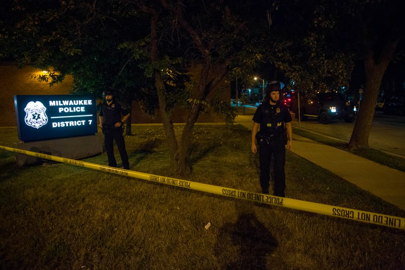 Police officers stand guard at Milwaukee’s District 7 police station as angry crowds take to the streets for a second night Aug. 14, 2016, to protest an officer-involved killing.Darren Hauck/Getty Images