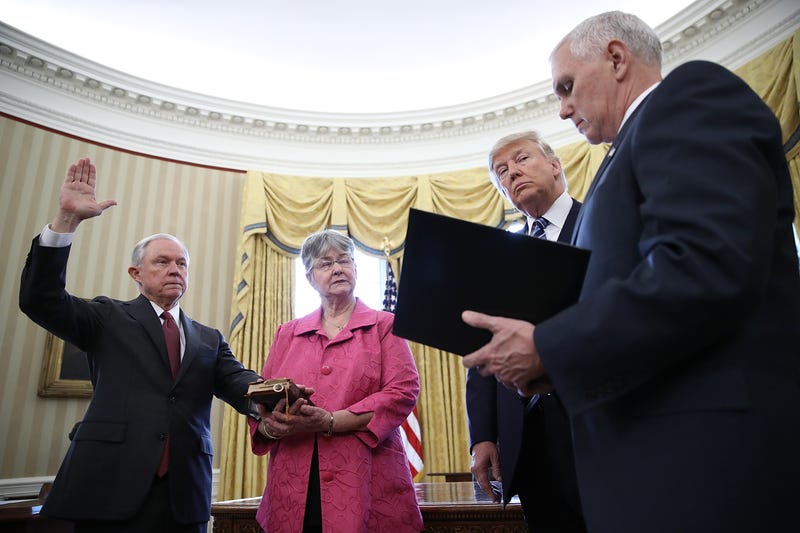 President Donald Trump (2nd R) watches as Jeff Sessions (L) is sworn-in as the new U.S. Attorney General by U.S. Vice President Mike Pence (R) in the Oval Office of the White House February 9, 2017 in Washington, DC. Trump also signed three executive orders immediately after the swearing in ceremony. Also pictured is Sessions’s wife, Mary (2nd L), holding the bible.