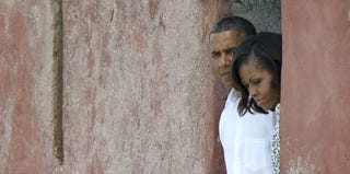 The president and the first lady peer out of the Door of No Return while touring Africa. (Jim Watson/AFP/Getty Images)