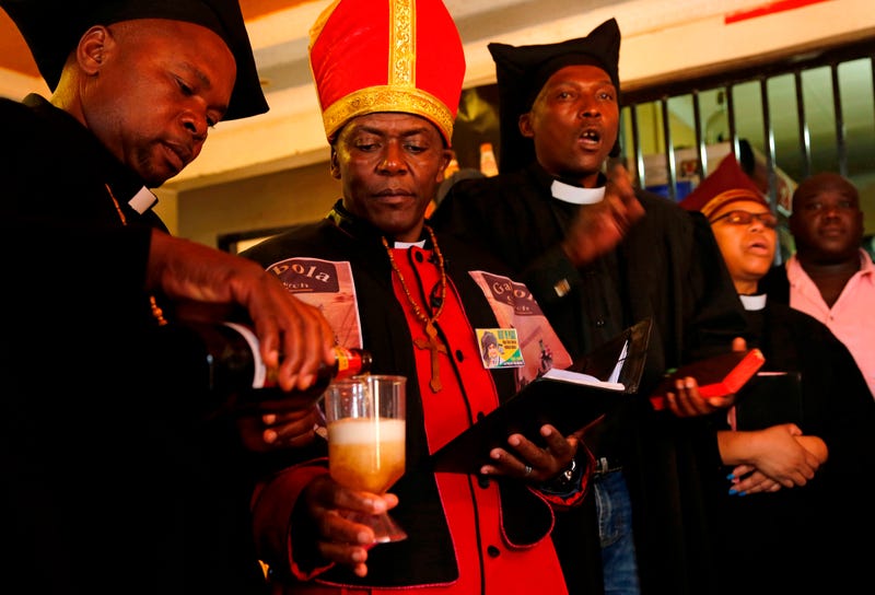 Leader of the Gabola Church Tsietsi Makiti (second from left) prepares to baptize newcomers to the church during a service in a bar in Orange Farm, south of Johannesburg, April 15, 2018.
